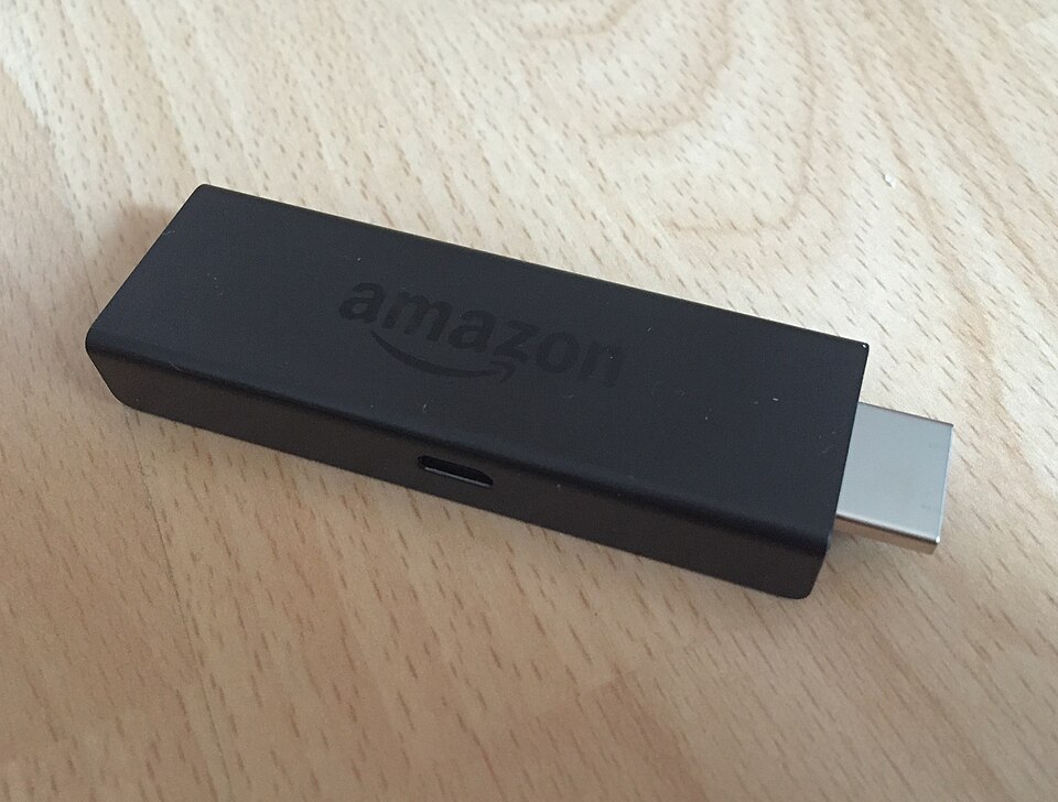 Συσκευή Amazon Fire TV Stick πάνω σε ξύλινο τραπέζι, κατάλληλη για IPTV με username και password